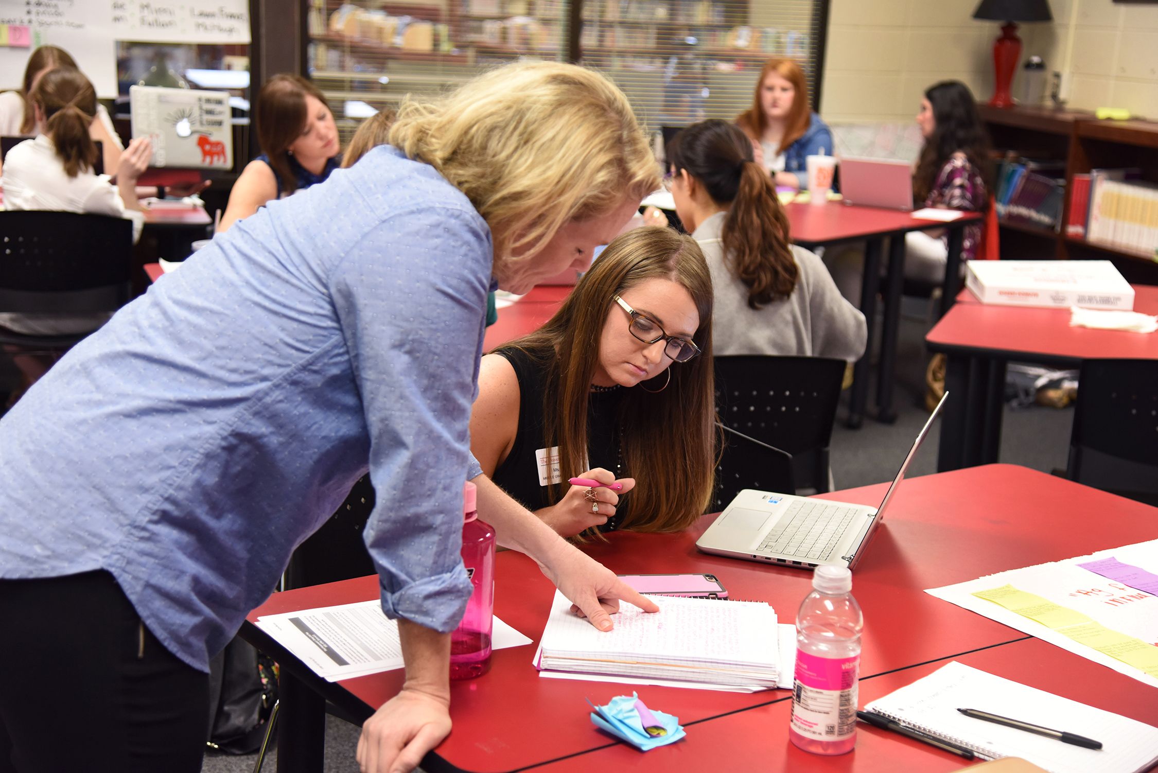 Teacher helping a student solve a problem in the classroom.